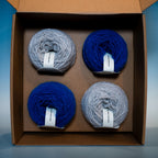 open cheekit box with four balls of loop 8 yarn in two colours